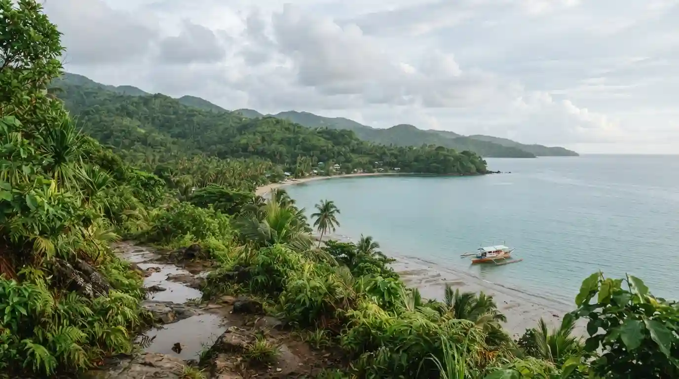 Lush Philippine coastline with tropical greenery and a traditional boat after rainfall